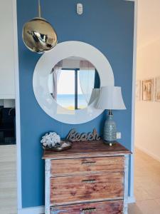 1 dormitorio con pared azul, espejo y tocador en SunnyCliff, en Rewal
