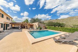 a swimming pool with chairs and a house at Villa Prital by Sealand Villas in Pollença