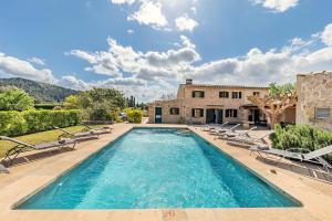 a swimming pool with chairs and a house at Villa Prital by Sealand Villas in Pollença