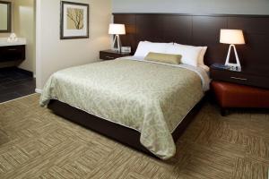 a hotel room with a large bed and two lamps at Sonesta ES Suites San Jose - Airport in San Jose
