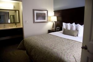 Habitación de hotel con cama, lavabo y espejo en Sonesta ES Suites San Jose - Airport en San José
