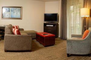 uma sala de estar com 2 cadeiras e uma televisão de ecrã plano em Sonesta ES Suites San Jose - Airport em San Jose