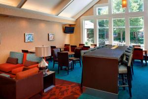 a waiting room with chairs and tables and a bar at Sonesta ES Suites Chicago Waukegan Gurnee in Waukegan