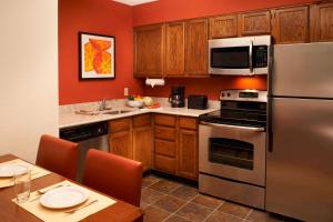 a kitchen with stainless steel appliances and wooden cabinets at Sonesta ES Suites Chicago Waukegan Gurnee in Waukegan