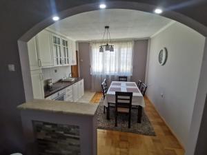 una cucina e una sala da pranzo con tavolo e sedie di Apartman Andrija a Trebinje