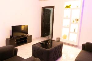 uma sala de estar com um sofá e uma televisão em Easyinn Shortlet Apartment em Port Harcourt