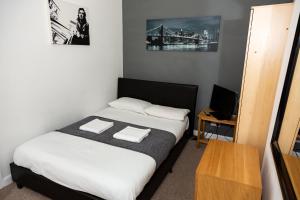 a bedroom with a bed with two towels on it at Alexander Apartments Rooms 2 in South Shields