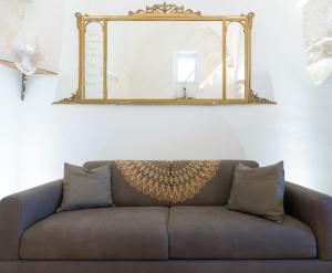 a couch with a mirror above it in a living room at BELLE HOME OSTUNI vasca vista mare in Ostuni