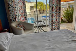 A bed or beds in a room at Amerique Hotel Palavas - Piscine & Parking - Plage
