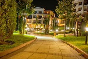 a walkway in a park at night with buildings at Niya Apartments Kavaci Sozopol GREEN LIFE in Sozopol