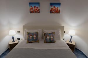 Cette chambre comprend un lit avec deux lampes et deux photos sur le mur. dans l'établissement La Rocca, à Nicosia