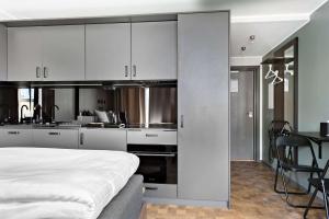 a kitchen with white cabinets and a bed in a room at Sure Hotel Studio by Best Western Bromma in Stockholm