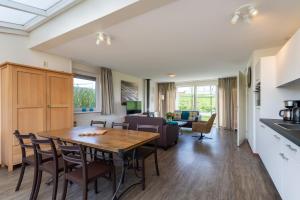 a kitchen and living room with a table and chairs at Antibes 240 - Kustpark Village Scaldia in Hoofdplaat