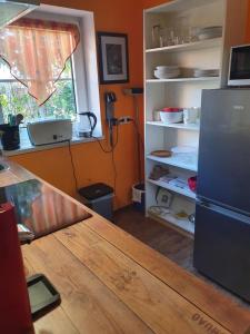 eine Küche mit einem Holztisch und einem Kühlschrank in der Unterkunft Olle Kolle in Wremen