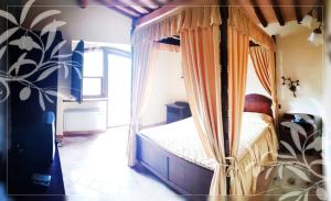 a bedroom with a canopy bed in a room at Il Colombaio Agriturismo in Montegabbione