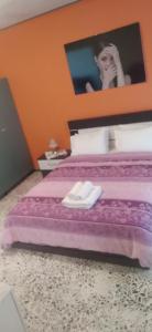 una mujer está de pie sobre una cama con dos toallas blancas en Cozy house 3, en Vrachati