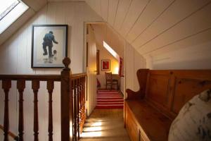 a hallway of a house with a staircase and a picture at The Wee Cottage in Drumnadrochit