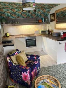 a living room with a couch in a kitchen at The Wee Cottage in Drumnadrochit