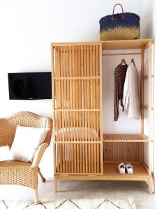 uma estante de madeira com roupas e uma cadeira num quarto em Lobeira - Centenary country house and gardens em Beja