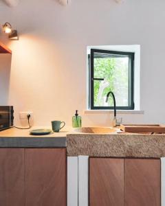 a kitchen with a sink and a window at Lobeira - Centenary country house and gardens in Beja