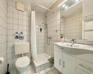 a white bathroom with a toilet and a sink at Studios in Osnabrück - Iburger Str. I home2share in Osnabrück