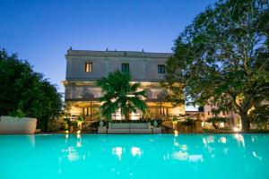 a building with a pool of water in front of it at Hotel Parco delle Fontane in Siracusa
