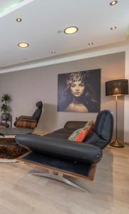 una sala de estar con una silla reclinable de cuero negro en City Wohnung Relax 3 klimatisiert en Friedrichshafen