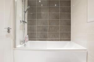 La salle de bains est pourvue d'une baignoire, d'une douche et d'un lavabo. dans l'établissement Southbank Leeds Apartment. New! With Free Parking, à Leeds
