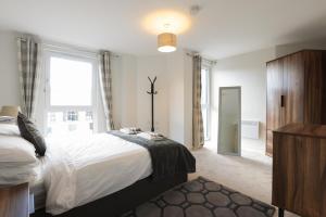 a bedroom with a large bed and a window at Southbank Leeds Apartment. New! With Free Parking in Leeds