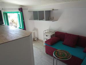 a living room with a red couch and a kitchen at KATY&MLADEN in Baška