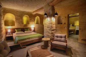 a bedroom with a bed and a chair in a room at 1811 Cave Hotel in Nevsehir