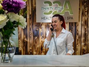 Une femme qui parle sur un téléphone portable à côté d'une table dans l'établissement Springfield Hotel & Health Club, à Halkyn