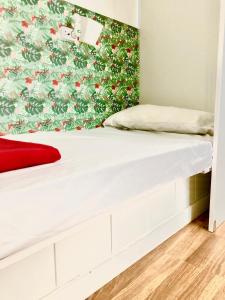 a bed in a room with a floral wall at Backpackers Las Eras in Santa Cruz de Tenerife