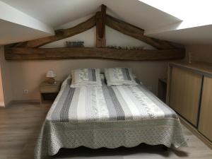 een slaapkamer met een groot bed op zolder bij Gîte de brizolles in Cluny