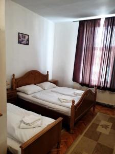 two twin beds in a room with a window at HOTEL MARION in Dumbrăveni