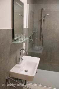 a bathroom with a sink and a shower with a mirror at Aparthotel Layblick in Senhals