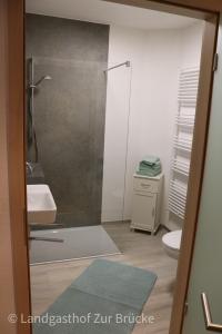 a bathroom with a shower and a sink and a toilet at Aparthotel Layblick in Senhals