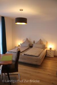 a bedroom with two beds and a table and a lamp at Aparthotel Layblick in Senhals