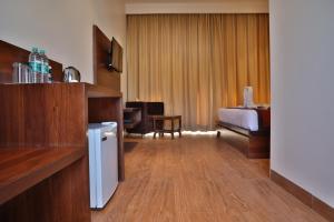 a hotel room with a bedroom with a bed and a desk at Mannat Resort Paota in Prāgpura
