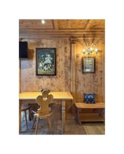 NONNA PINA Appartamento PUTTI في بادولا: غرفة طعام مع طاولة وكراسي خشبية