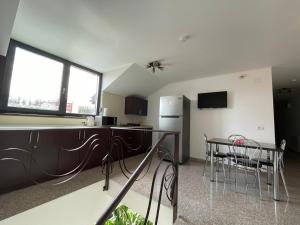 uma cozinha com uma mesa e cadeiras e um frigorífico em Dr House em Mioveni