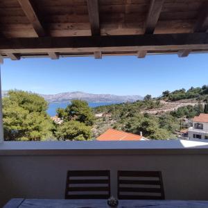 uma vista da sala de jantar com vista para a água em Nika em Postira