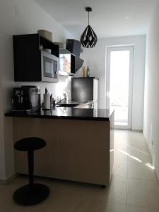 a kitchen with a black counter top and a stool at FRANTA in Cres