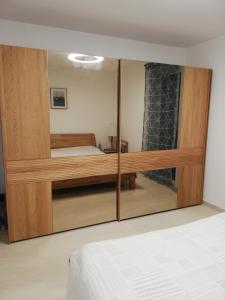 a bedroom with a large wooden closet with a mirror at FRANTA in Cres