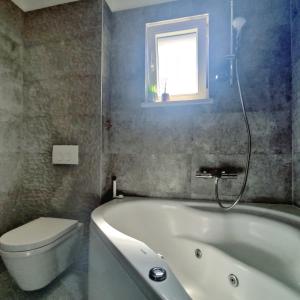 a bathroom with a tub and a toilet and a window at Nika in Postira +22 photos
