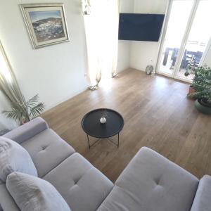 uma sala de estar com um sofá e uma mesa em Nika em Postira