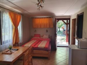 a bedroom with a bed and a desk and a table at Strand Apartmanok in Bogács