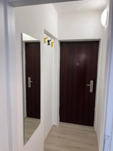 a hallway with two brown doors and a mirror at Center of Plitvice + Free Parking + Self Check-in in Plitvička Jezera