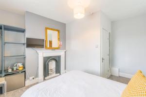 a bedroom with a white bed and a fireplace at InTown - 60 second walk 2 Minster! in York +5 photos