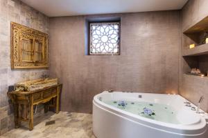een badkamer met een groot bad en een raam bij Boutique Hotel Horizont in Varna